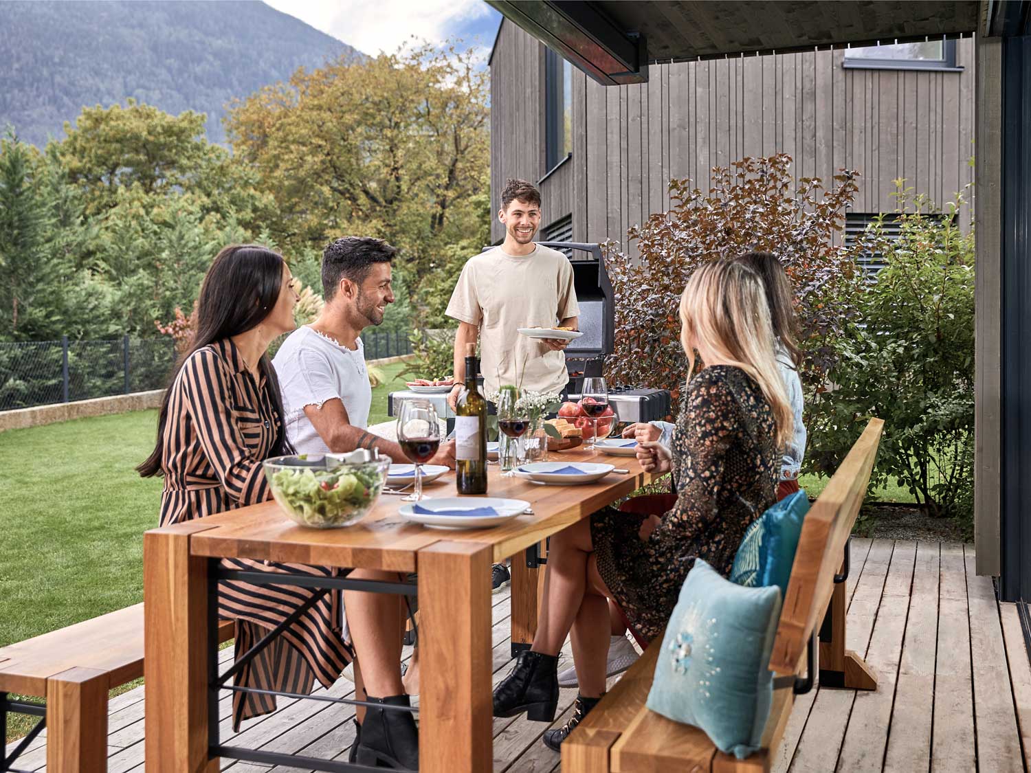 Sulla terrazza, cinque persone mangiano sul set di design Lago.